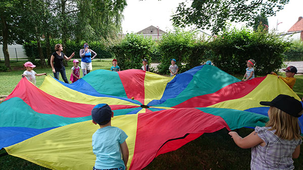 enfants jouent avec toile sur l'herbe