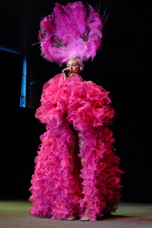 chanteuse avec une robe rose et un chapeau de plume